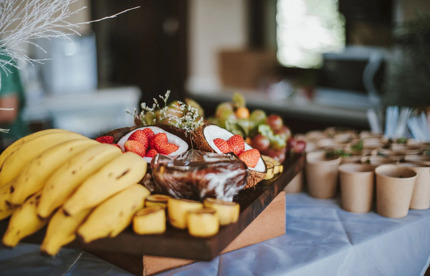A tropical fruit spread with coconut, strawberries and banana on a wooden board (representative photograph of a buffet spread, not the Center's own table)